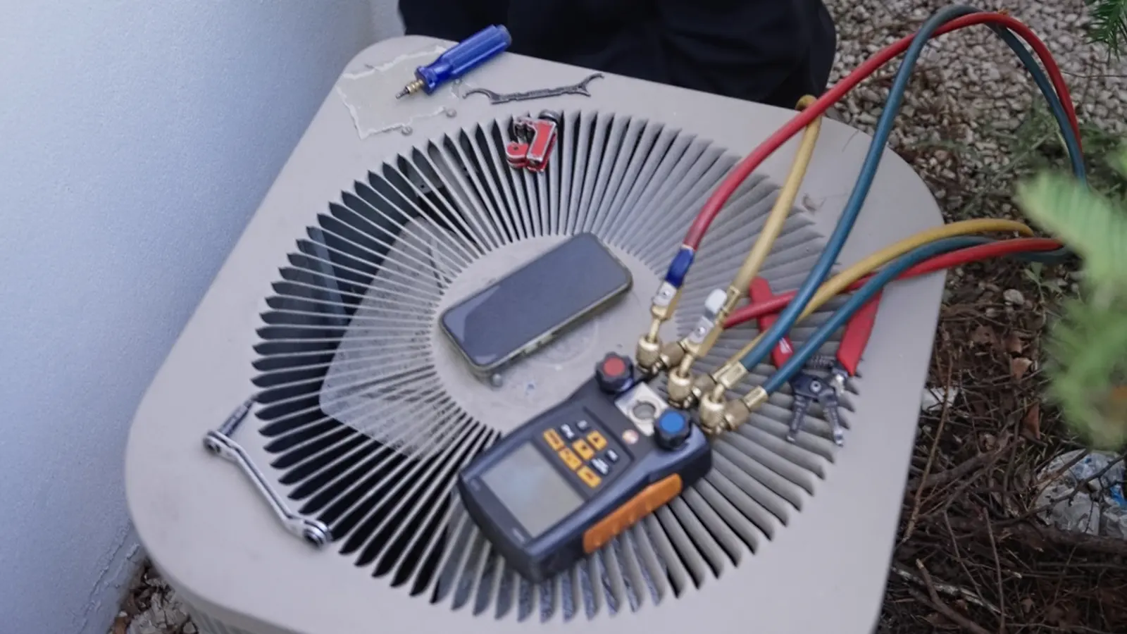 Refrigerant gauges on an AC condenser during a tune-up