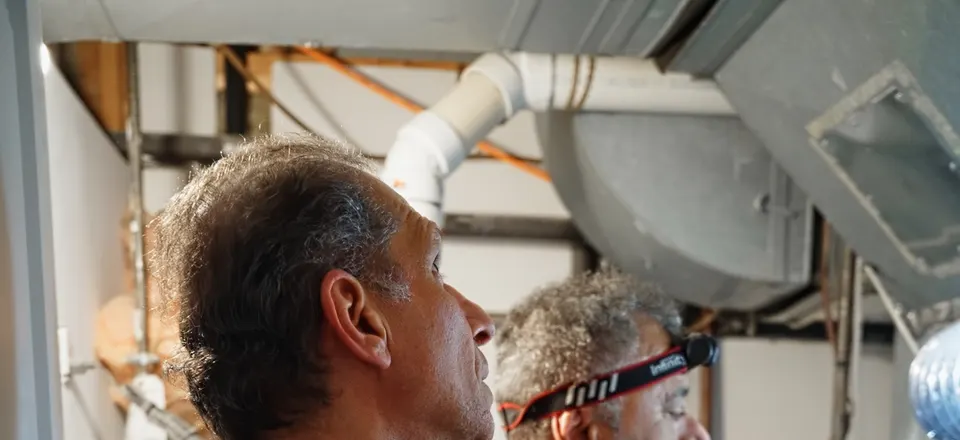 H&C technician inspecting mechanical equipment overhead